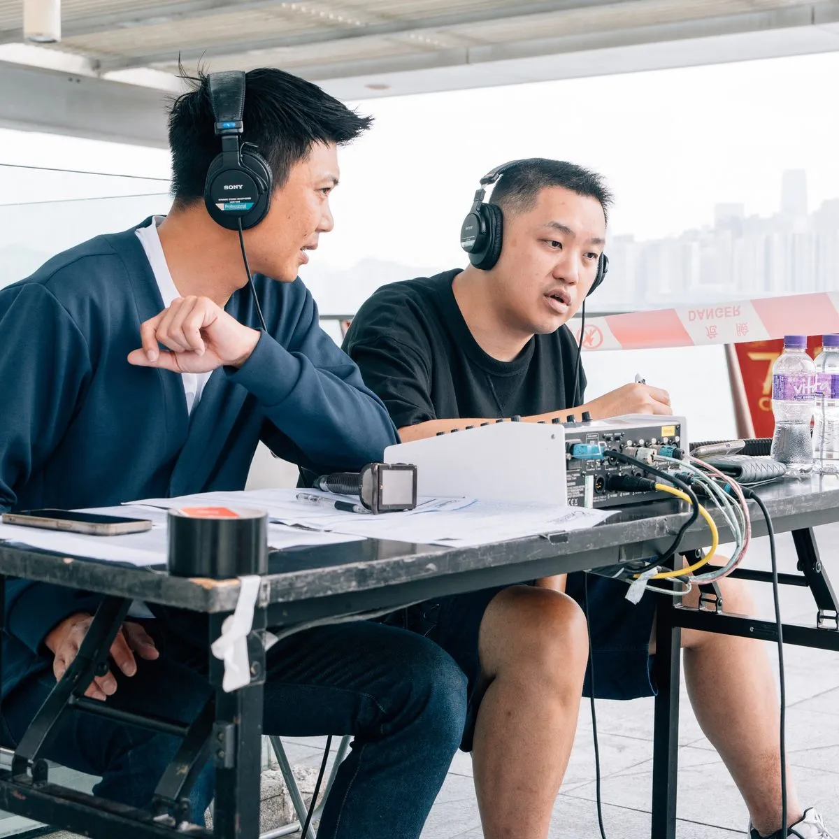Two commentators on headsets calling the race from the open-air commentary position