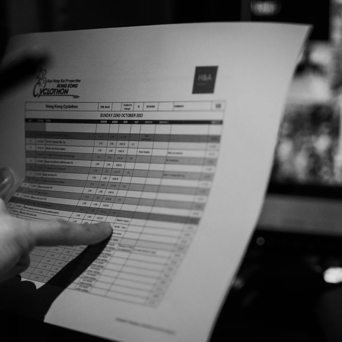 A hand tracing the H&A running order for the Hong Kong Cyclothon broadcast