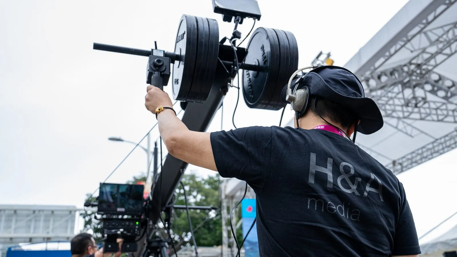 An H&A Media camera operator shouldering the live camera on a jib arm at a city event